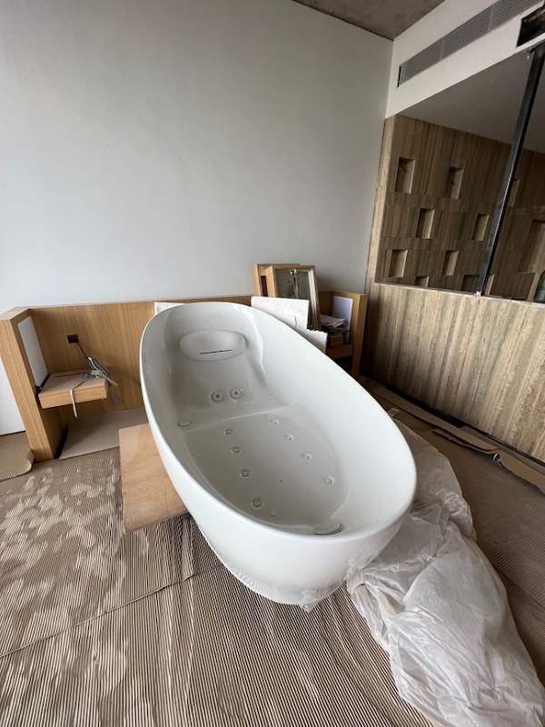 Before: the bathroom as a bare shell with the freestanding bathtub still unfitted on the floor - Condo apartment renovation with a limestone feature wall and dark green kitchen (38MR) | Larry Contractors, HDB Licensed Renovation Contractor, Singapore