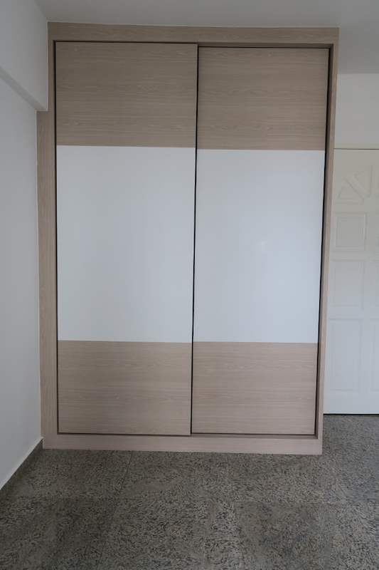 Sliding-door wardrobe in light wood and white laminate with the doors closed - HDB resale flat renovation with polished terrazzo floors, new kitchen and bathrooms (C04) | Larry Contractors, HDB Licensed Renovation Contractor, Singapore