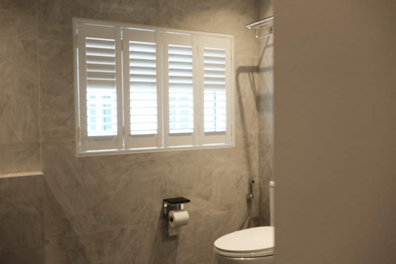 Bathroom in large-format grey tiles with a window fitted with white plantation shutters - Terrace house renovation with new facade and full interior (3TBA) | Larry Contractors, HDB Licensed Renovation Contractor, Singapore