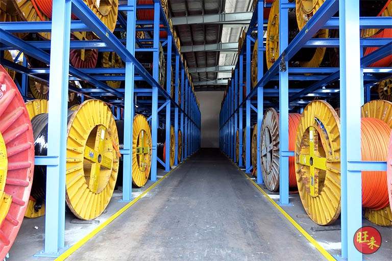 Aisle between loaded racks under the shed roof with yellow floor markings - Heavy-duty cable drum racking in a cable yard (TSE) | Larry Contractors, HDB Licensed Renovation Contractor, Singapore