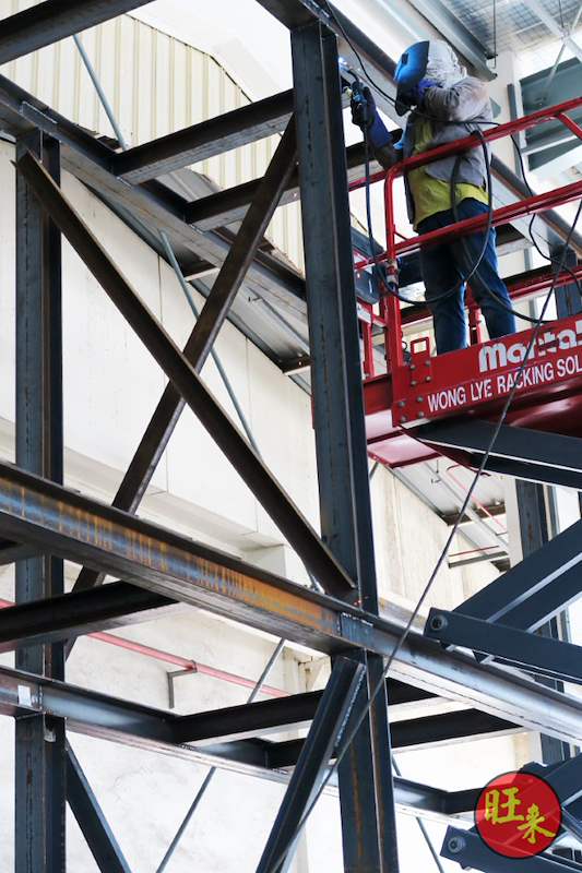 During works: welding the diagonal bracing of the steel frame from a scissor lift - Heavy-duty cable drum racking in a cable yard (TSE) | Larry Contractors, HDB Licensed Renovation Contractor, Singapore