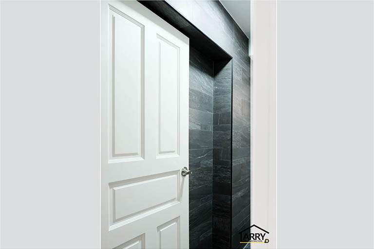 White panelled door and the dark slate-look tiled wall around it - HDB flat renovation with a blue kitchen and a glass-walled walk-in wardrobe (C18) | Larry Contractors, HDB Licensed Renovation Contractor, Singapore