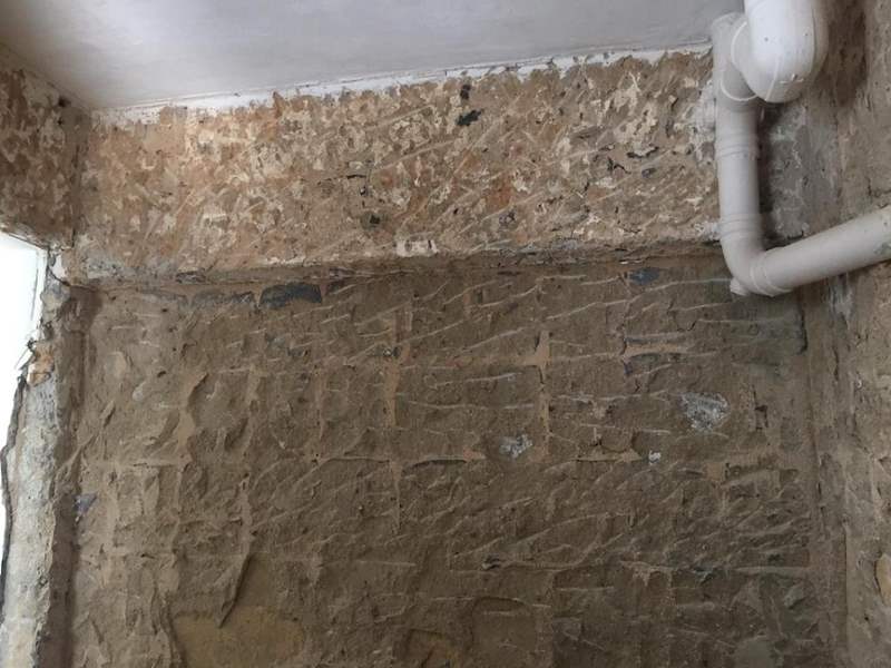 During works: a wall hacked to bare brick with pipes running along the ceiling - HDB resale flat renovation with polished terrazzo floors, new kitchen and bathrooms (C04) | Larry Contractors, HDB Licensed Renovation Contractor, Singapore
