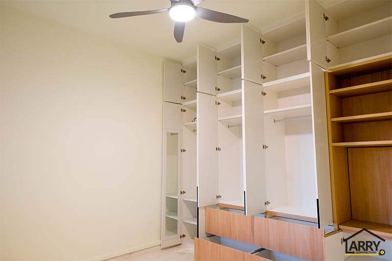 Built-in wardrobes opened to show the shelving, hanging rails and drawers inside - HDB flat renovation with full-height carpentry and a wood-tone kitchen (C12) | Larry Contractors, HDB Licensed Renovation Contractor, Singapore