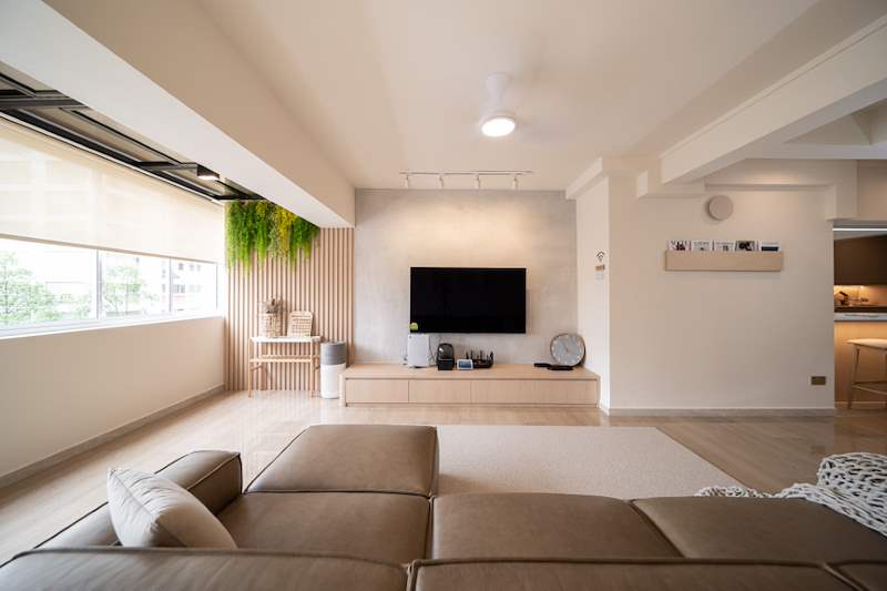 Living room after renovation with a brown sofa, timber-slat feature wall, hanging plants and a wall-mounted TV - Full HDB maisonette renovation with a curved timber-slat island and lit staircase (140BB) | Larry Contractors, HDB Licensed Renovation Contractor, Singapore