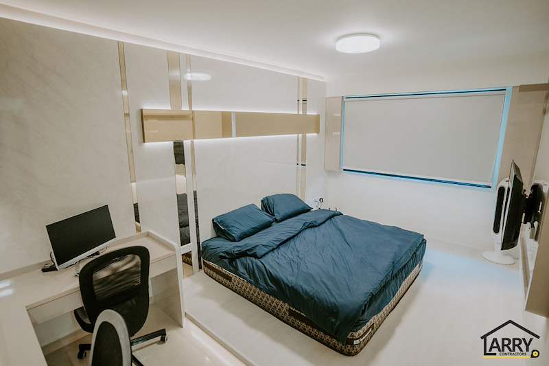 Bedroom with a blue-covered bed, built-in desk, roller blind and cream laminate wardrobes - HDB flat renovation in cream and mirror-trim laminate with a galley kitchen (C10) | Larry Contractors, HDB Licensed Renovation Contractor, Singapore