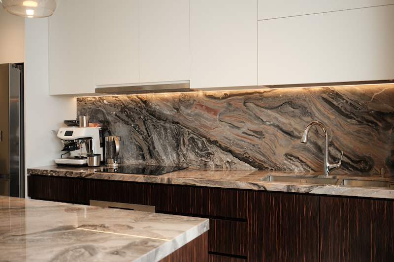 Kitchen run with white upper cabinets, a veined stone splashback and worktop and dark wood-grain drawers - Terrace house renovation with new facade and full interior (3TBA) | Larry Contractors, HDB Licensed Renovation Contractor, Singapore