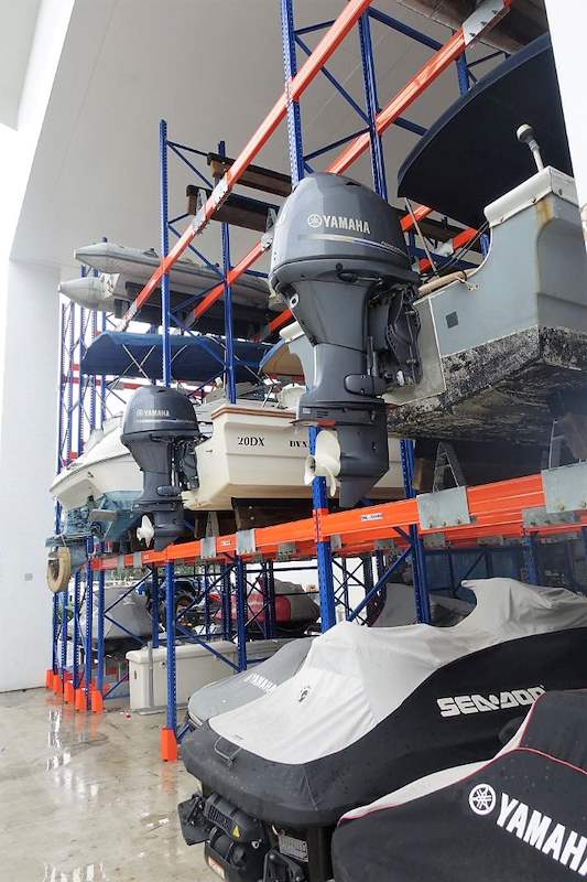 Jet ski at floor level in front of the rack with outboard boats stored on the tier above - Heavy-duty storage racking for boats and jet skis (Sentosa) | Larry Contractors, HDB Licensed Renovation Contractor, Singapore
