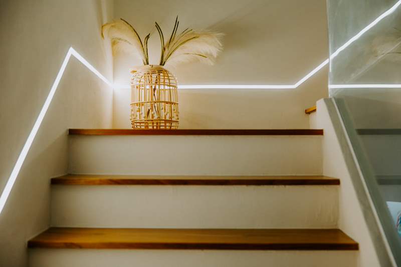 Timber-tread staircase with an LED light line running up the wall - Full HDB maisonette renovation with a curved timber-slat island and lit staircase (140BB) | Larry Contractors, HDB Licensed Renovation Contractor, Singapore