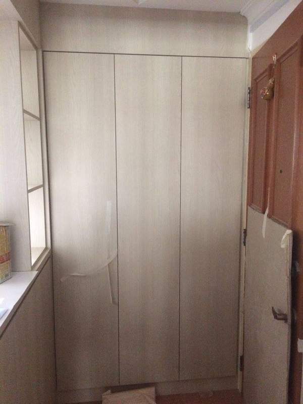 Light wood-grain full-height cabinet fitted beside the flat entrance door - HDB kitchen carpentry in cream laminate with a built-in oven (C07) | Larry Contractors, HDB Licensed Renovation Contractor, Singapore
