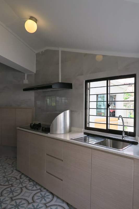 After: kitchen worktop with a gas hob, stainless sink and cooker hood under a grilled window - HDB kitchen, bathroom and service yard renovation (140PP) | Larry Contractors, HDB Licensed Renovation Contractor, Singapore