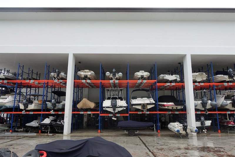 Rows of two-tier boat racking under a covered shed, boats on the upper beams and covered craft below - Heavy-duty storage racking for boats and jet skis (Sentosa) | Larry Contractors, HDB Licensed Renovation Contractor, Singapore