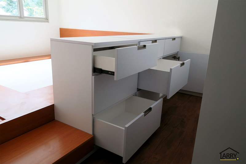 After: white drawers built into the side of the raised bedroom platform, with a timber-laminate top - HDB flat renovation with a platform bay window seat and blue kitchen (C20) | Larry Contractors, HDB Licensed Renovation Contractor, Singapore
