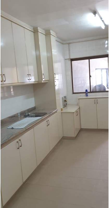 Before: old white kitchen cabinets and worktop beside a window - HDB resale flat renovation with polished terrazzo floors, new kitchen and bathrooms (C04) | Larry Contractors, HDB Licensed Renovation Contractor, Singapore