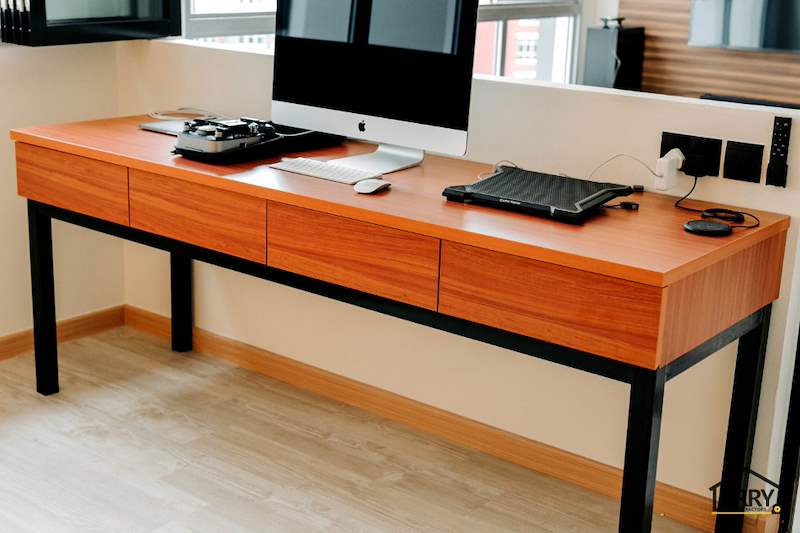 Long timber desk with drawers on black steel legs, computer and keyboard on top, window behind - HDB flat renovation with a glass-partitioned study, hidden shoe cabinet and navy kitchen (442BB) | Larry Contractors, HDB Licensed Renovation Contractor, Singapore