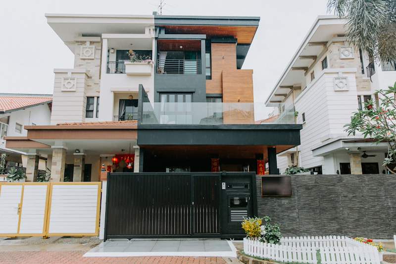 After: the completed front elevation with timber cladding, dark panels and a glass balcony balustrade - Landed house renovation with new facade, staircase and interiors (39EW) | Larry Contractors, HDB Licensed Renovation Contractor, Singapore