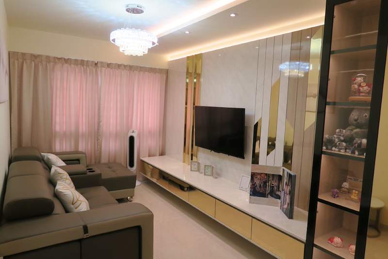 Living room with pink curtains, a leather sofa, wall-mounted TV and lit display cabinet - HDB flat renovation in cream and mirror-trim laminate with a galley kitchen (C10) | Larry Contractors, HDB Licensed Renovation Contractor, Singapore