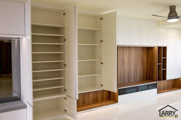 Tall white cabinets opened to show the shelving inside, TV feature wall beyond - HDB flat renovation with full-height carpentry and a wood-tone kitchen (C12) | Larry Contractors, HDB Licensed Renovation Contractor, Singapore