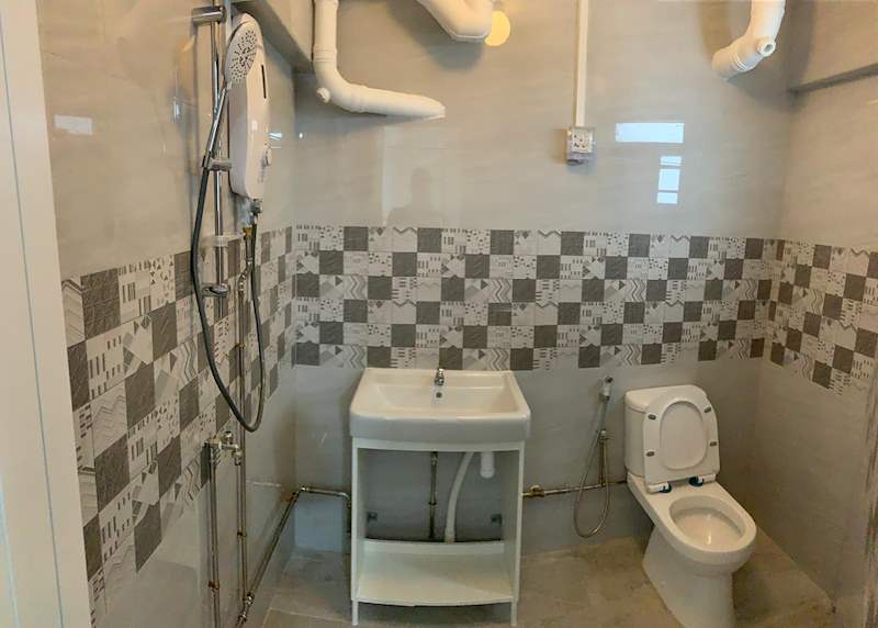 Bathroom with a shower heater, white basin, toilet and a patterned tile band - HDB resale flat renovation with polished terrazzo floors, new kitchen and bathrooms (C04) | Larry Contractors, HDB Licensed Renovation Contractor, Singapore