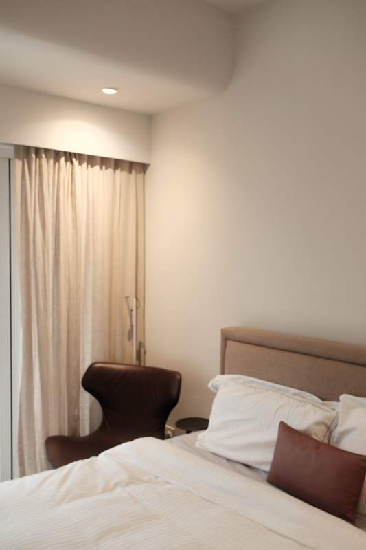 Bedroom with an upholstered headboard, a leather armchair and curtains at the window - Terrace house renovation with new facade and full interior (3TBA) | Larry Contractors, HDB Licensed Renovation Contractor, Singapore
