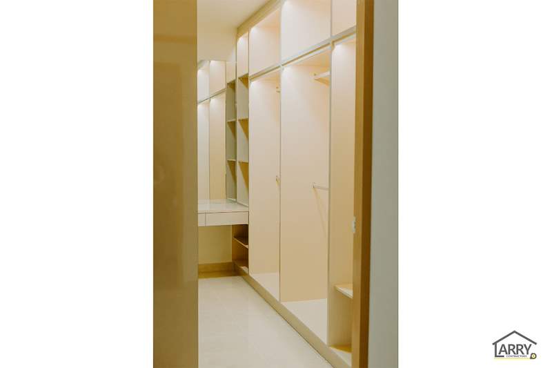 Walk-in wardrobe with lit open shelving, hanging rails and drawers in cream laminate - HDB flat renovation in cream and mirror-trim laminate with a galley kitchen (C10) | Larry Contractors, HDB Licensed Renovation Contractor, Singapore