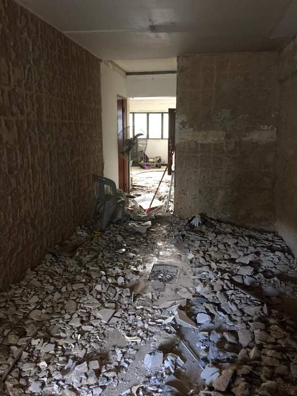 During demolition: the hallway with walls hacked to brick and rubble on the floor - HDB resale flat renovation with polished terrazzo floors, new kitchen and bathrooms (C04) | Larry Contractors, HDB Licensed Renovation Contractor, Singapore