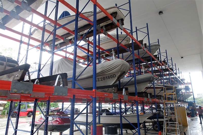 Three-tier boat racks with an access ladder, boats on the upper tiers and a car parked at floor level - Heavy-duty storage racking for boats and jet skis (Sentosa) | Larry Contractors, HDB Licensed Renovation Contractor, Singapore