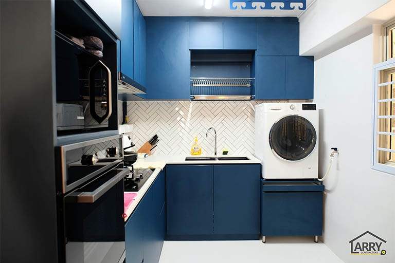 L-shaped navy blue kitchen with a built-in oven, dish rack and a front-loading washing machine - HDB flat renovation with a blue kitchen and a glass-walled walk-in wardrobe (C18) | Larry Contractors, HDB Licensed Renovation Contractor, Singapore