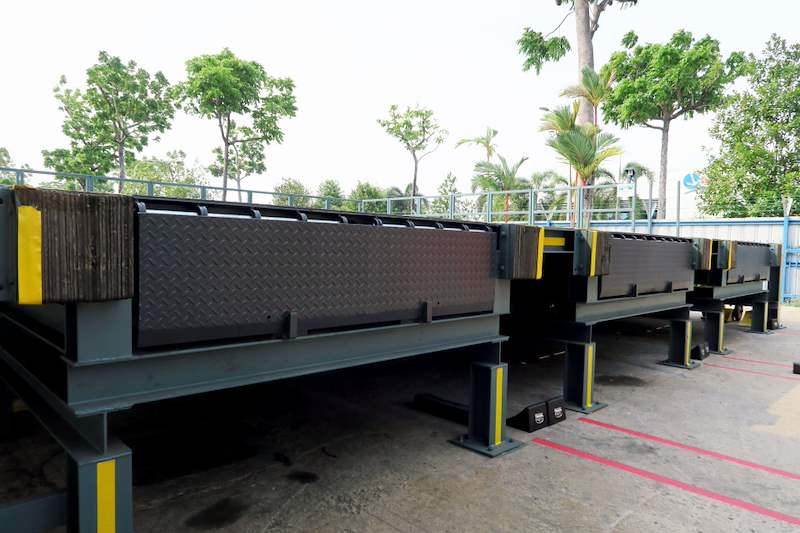 Checker-plate steel loading dock platforms on posts in the yard with hazard-striped edges - Heavy-duty cable drum racking in a cable yard (TSE) | Larry Contractors, HDB Licensed Renovation Contractor, Singapore