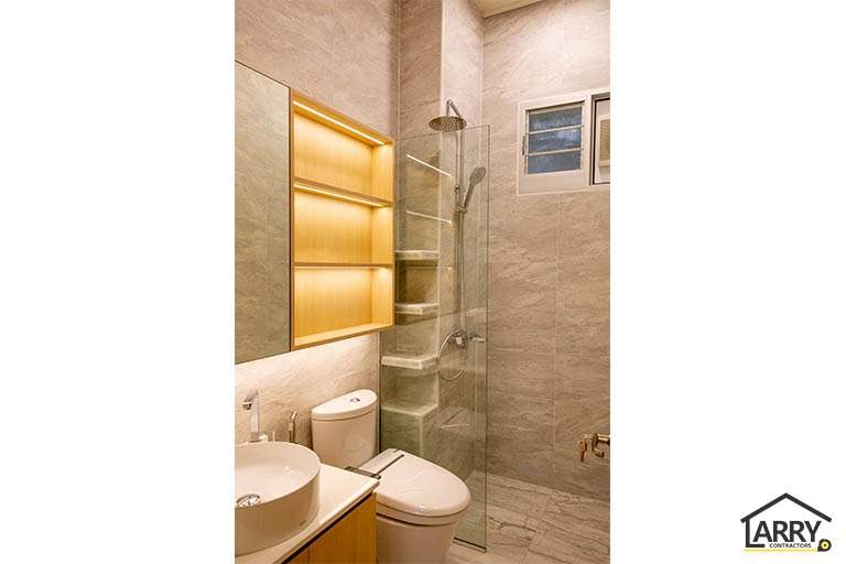 Bathroom in marble-look tiles with a glass shower screen and a backlit shelf niche - HDB flat renovation with full-height carpentry and a wood-tone kitchen (C12) | Larry Contractors, HDB Licensed Renovation Contractor, Singapore