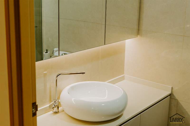 Bathroom vanity with a round white countertop basin, a chrome mixer tap and a lit mirror cabinet - HDB flat renovation in cream and mirror-trim laminate with a galley kitchen (C10) | Larry Contractors, HDB Licensed Renovation Contractor, Singapore