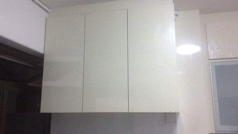 Cream laminate wall cabinets fitted above the worktop, viewed from below - HDB kitchen carpentry in cream laminate with a built-in oven (C07) | Larry Contractors, HDB Licensed Renovation Contractor, Singapore
