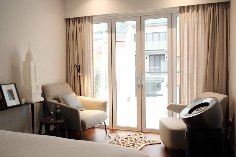 Sitting area at a full-height glazed door with sheer curtains, two armchairs and a timber floor - Terrace house renovation with new facade and full interior (3TBA) | Larry Contractors, HDB Licensed Renovation Contractor, Singapore