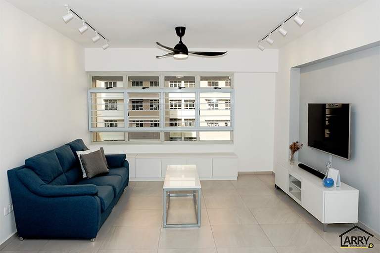 Living room with a blue fabric sofa, a white TV console and a ceiling fan, windows to the block opposite - HDB flat renovation with a blue kitchen and a glass-walled walk-in wardrobe (C18) | Larry Contractors, HDB Licensed Renovation Contractor, Singapore