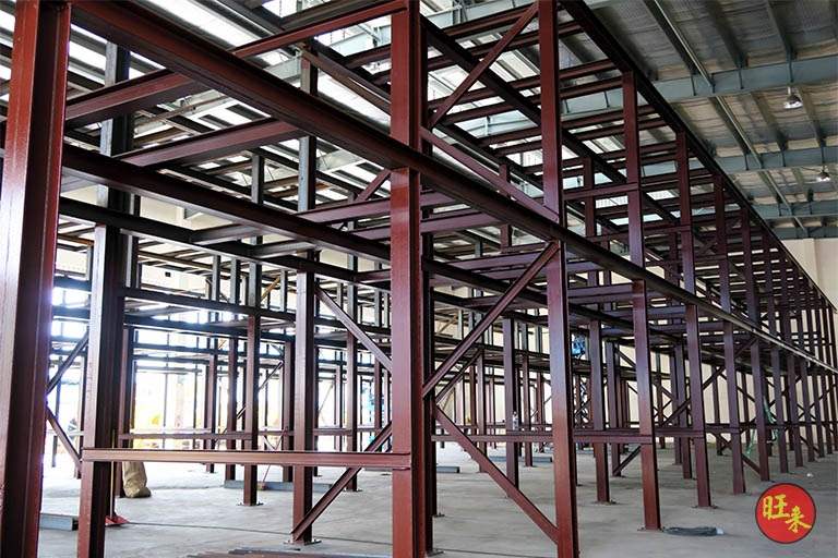 Rows of the steel racking frame in red primer inside the shed before loading - Heavy-duty cable drum racking in a cable yard (TSE) | Larry Contractors, HDB Licensed Renovation Contractor, Singapore