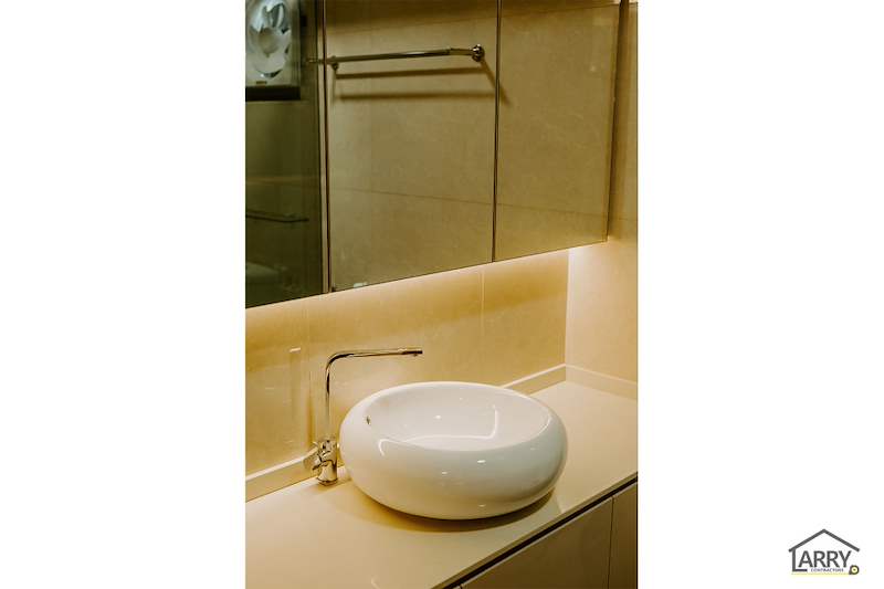 Round countertop basin on a stone-look vanity top with a backlit mirror above - HDB flat renovation in cream and mirror-trim laminate with a galley kitchen (C10) | Larry Contractors, HDB Licensed Renovation Contractor, Singapore