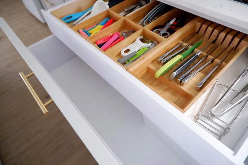 Kitchen drawer with a bamboo cutlery and utensil organiser, white shaker front and brass handle - HDB flat renovation in white shaker-style carpentry with brass handles (C05) | Larry Contractors, HDB Licensed Renovation Contractor, Singapore