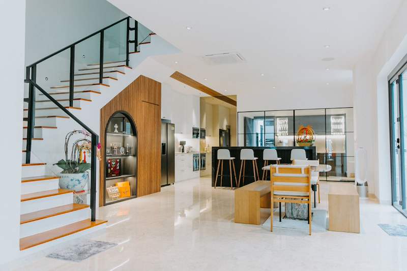 After: open-plan living and dining area with the new staircase and a timber-slat display niche built under it - Landed house renovation with new facade, staircase and interiors (39EW) | Larry Contractors, HDB Licensed Renovation Contractor, Singapore