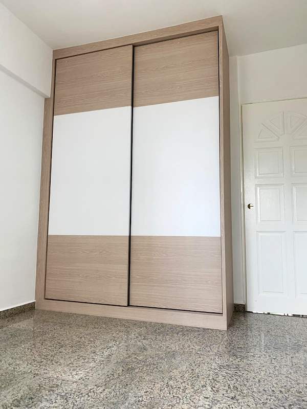 Sliding-door wardrobe in light wood and white laminate beside a white door - HDB resale flat renovation with polished terrazzo floors, new kitchen and bathrooms (C04) | Larry Contractors, HDB Licensed Renovation Contractor, Singapore