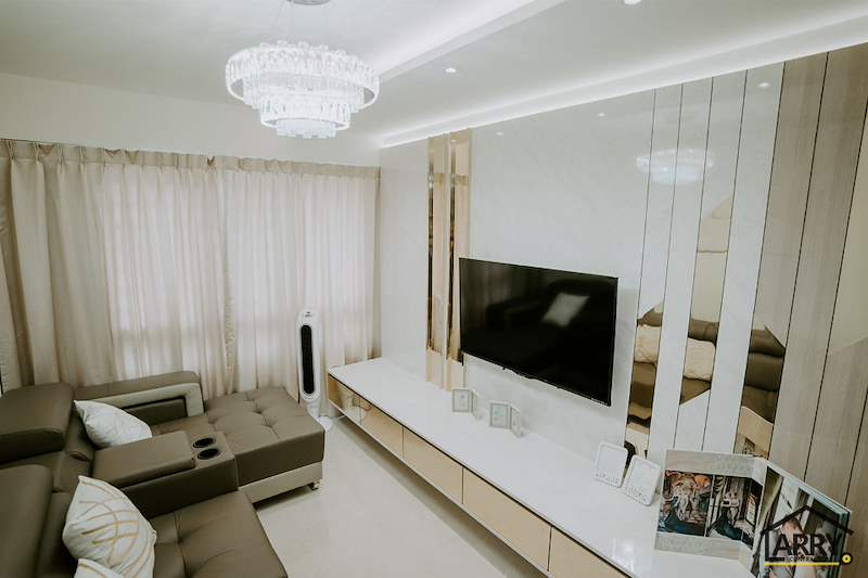 Living room TV wall in cream laminate with mirror strips, tiered crystal light and sheer curtains - HDB flat renovation in cream and mirror-trim laminate with a galley kitchen (C10) | Larry Contractors, HDB Licensed Renovation Contractor, Singapore