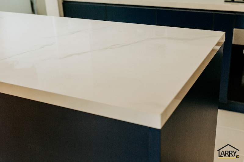 Close view of the marble-look worktop edge on a navy cabinet base - HDB flat renovation with a glass-partitioned study, hidden shoe cabinet and navy kitchen (442BB) | Larry Contractors, HDB Licensed Renovation Contractor, Singapore