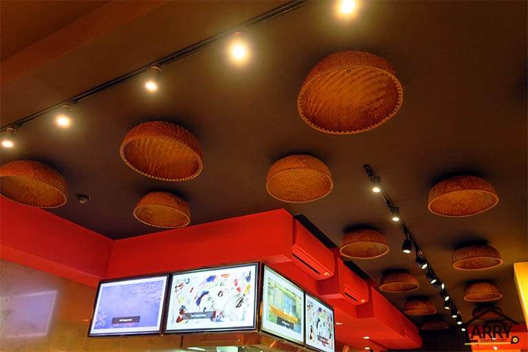Woven baskets fixed to the ceiling as light shades above the red bulkhead and menu screens - Restaurant fit-out with an open kitchen counter and marble frontage (C48) | Larry Contractors, HDB Licensed Renovation Contractor, Singapore