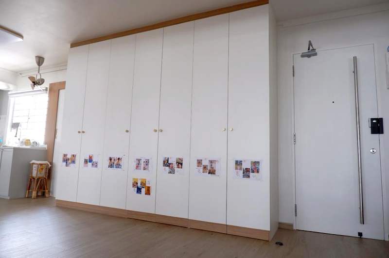 Bank of white full-height shaker-style wardrobes beside the flat entrance door - HDB flat renovation in white shaker-style carpentry with brass handles (C05) | Larry Contractors, HDB Licensed Renovation Contractor, Singapore