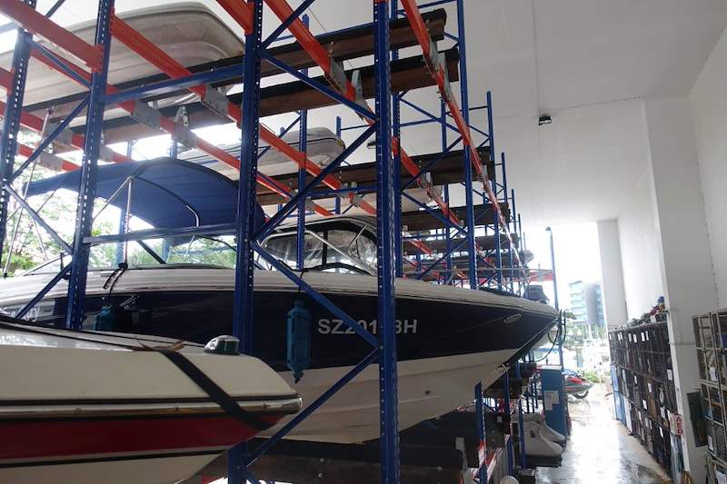 Speedboat stored on the second tier of the rack with a covered boat above it - Heavy-duty storage racking for boats and jet skis (Sentosa) | Larry Contractors, HDB Licensed Renovation Contractor, Singapore