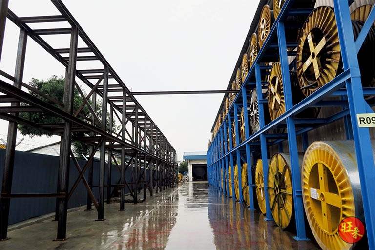 Outdoor racking with the yard steel frame in the foreground and drums loaded on the tiers - Heavy-duty cable drum racking in a cable yard (TSE) | Larry Contractors, HDB Licensed Renovation Contractor, Singapore