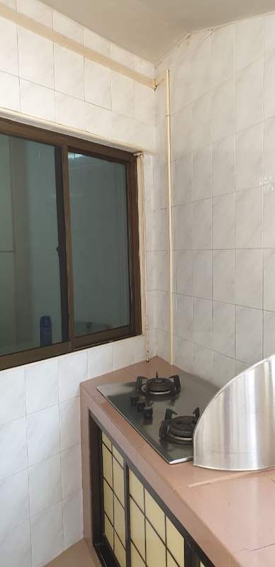Before: the old kitchen with a pink tiled counter, lattice-front cabinets and a window - HDB resale flat renovation with polished terrazzo floors, new kitchen and bathrooms (C04) | Larry Contractors, HDB Licensed Renovation Contractor, Singapore