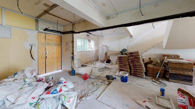 Before: the kitchen area stripped with cement bags, timber boards and exposed ceiling services - Full HDB maisonette renovation with a curved timber-slat island and lit staircase (140BB) | Larry Contractors, HDB Licensed Renovation Contractor, Singapore