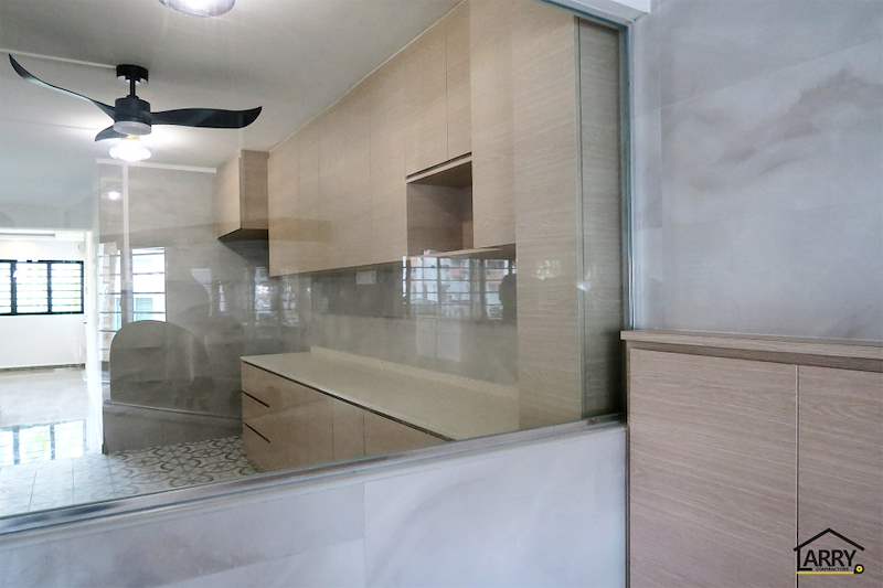 Kitchen seen through the glass partition from the living room, cabinets and ceiling fan visible - HDB resale flat renovation with polished terrazzo floors, new kitchen and bathrooms (C04) | Larry Contractors, HDB Licensed Renovation Contractor, Singapore