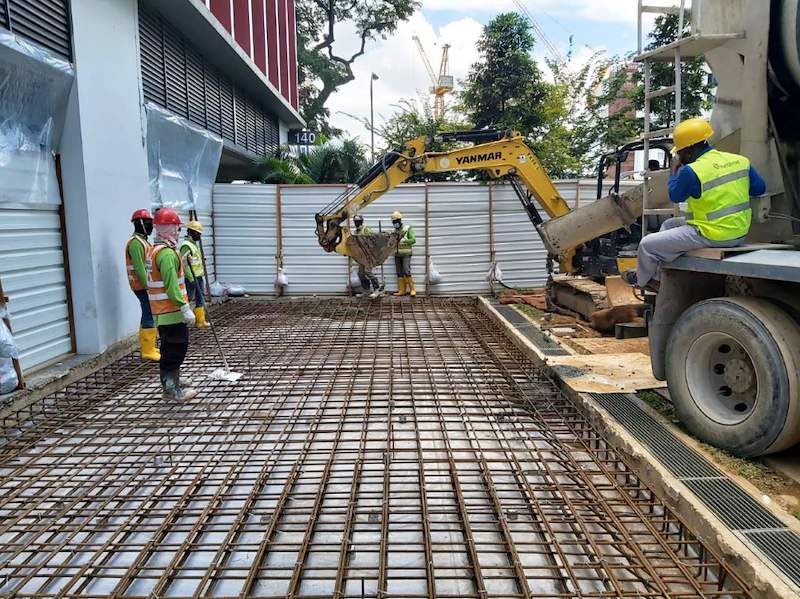 During works: steel reinforcement mesh laid for the new slab with a concrete truck and excavator on site - Covered dining extension for a coffee shop under an HDB block (140CD) | Larry Contractors, HDB Licensed Renovation Contractor, Singapore