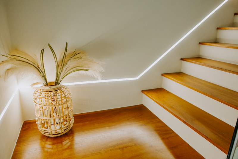 Staircase landing with timber treads, a rattan lantern and the LED light line - Full HDB maisonette renovation with a curved timber-slat island and lit staircase (140BB) | Larry Contractors, HDB Licensed Renovation Contractor, Singapore